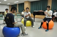 音楽に合わせてバランスボールで遊ぶ生徒たち