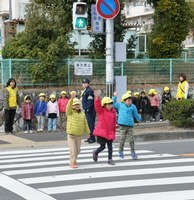 手を挙げて横断歩道を渡る園児たち