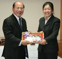 明田市長にラオスの風景が描かれた銅板を手渡す鈴木彩乃さん