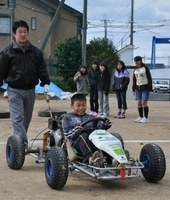 バイオ燃料で動くカートを運転する児童
