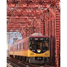 赤い鉄橋をくぐる京阪電車