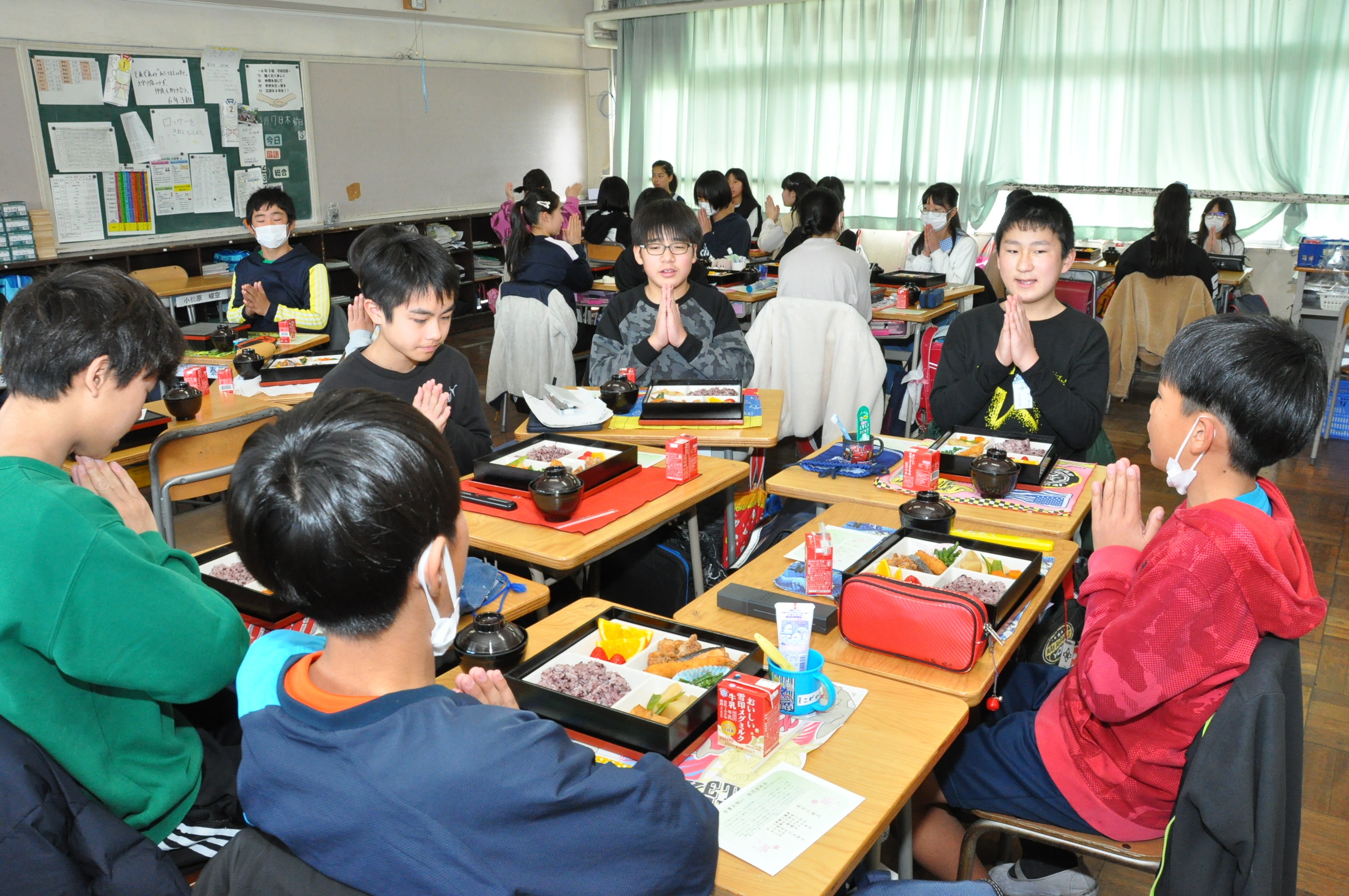 松花堂弁当を前にいただきますをする児童、松花堂弁当を食べる児童