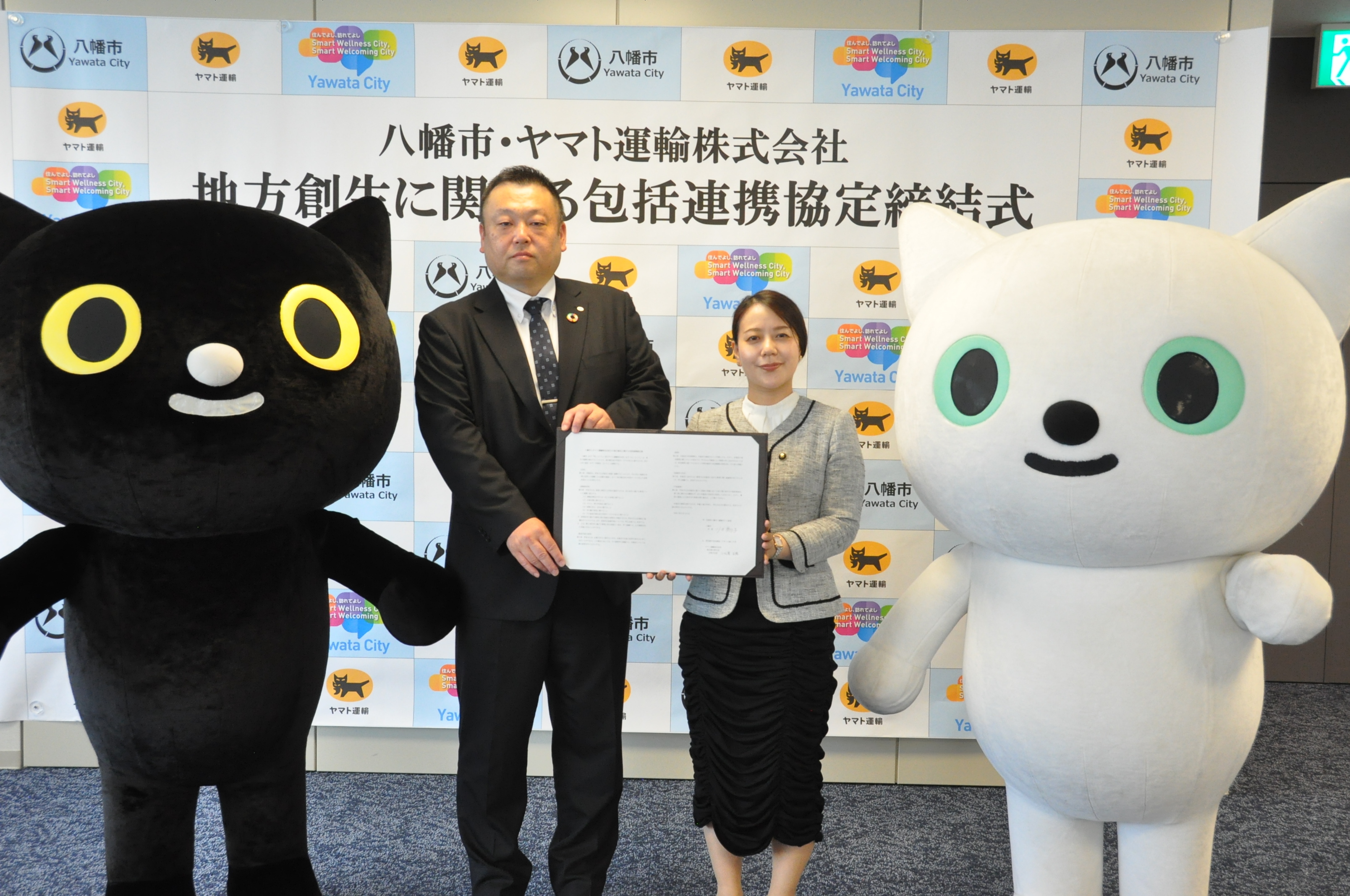 協定書を手にする小比賀支店長と川田市長