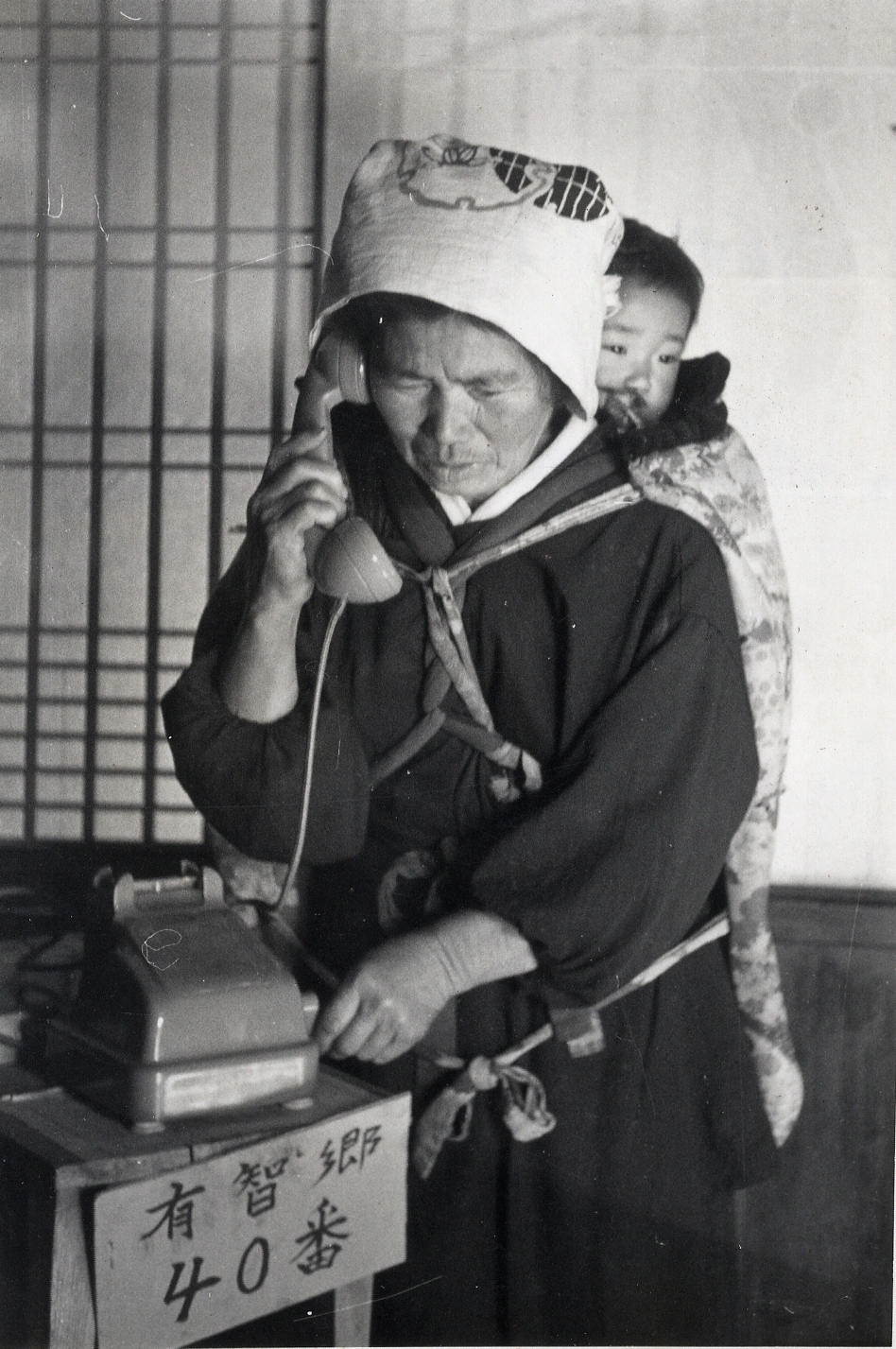 美濃山に農村公衆電話が開通し、電話をかける女性の写真（昭和34年（1958）12月）