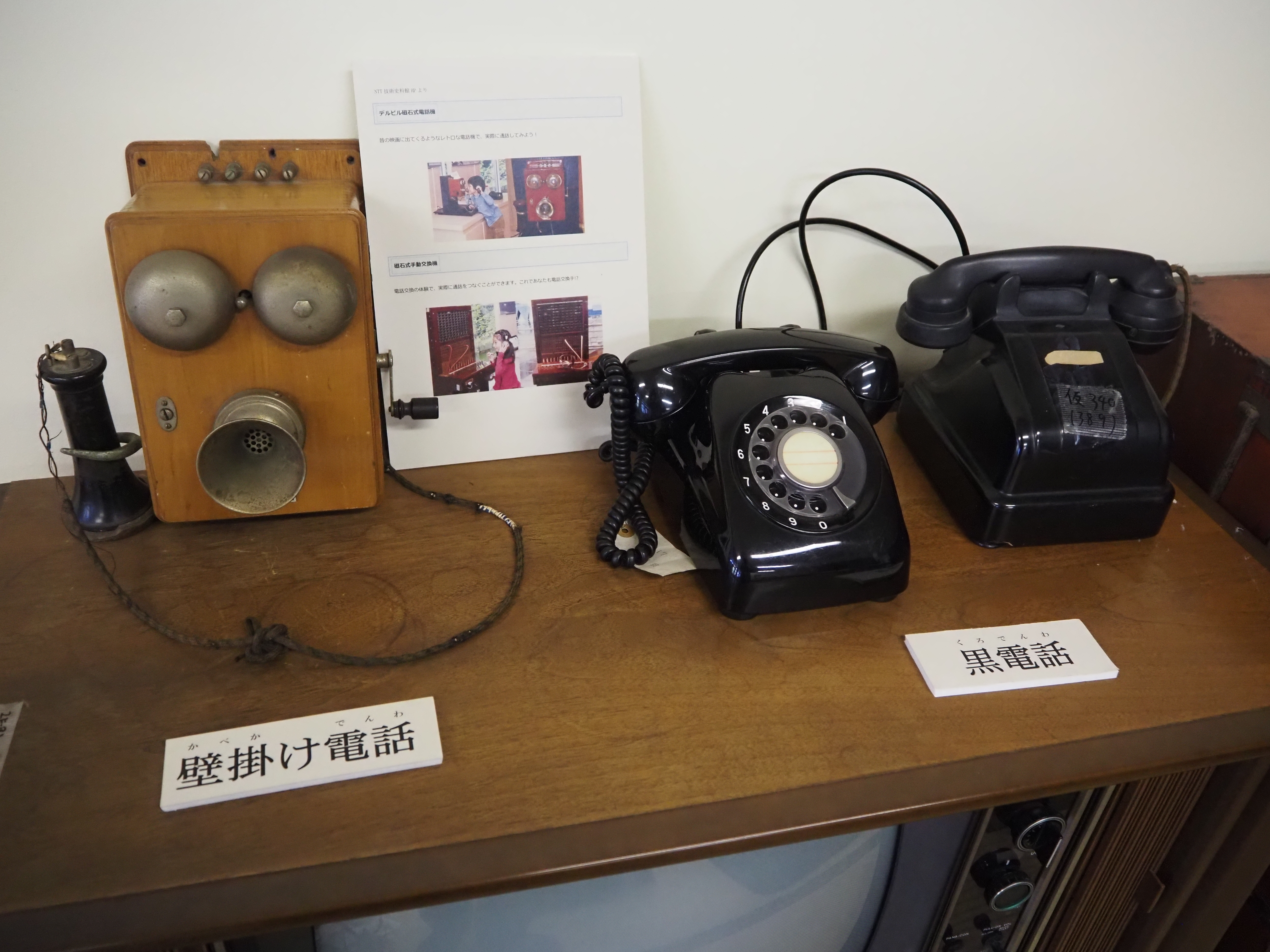 ふるさと学習館に展示されている電話機。壁掛け電話や黒電話などが並ぶ。